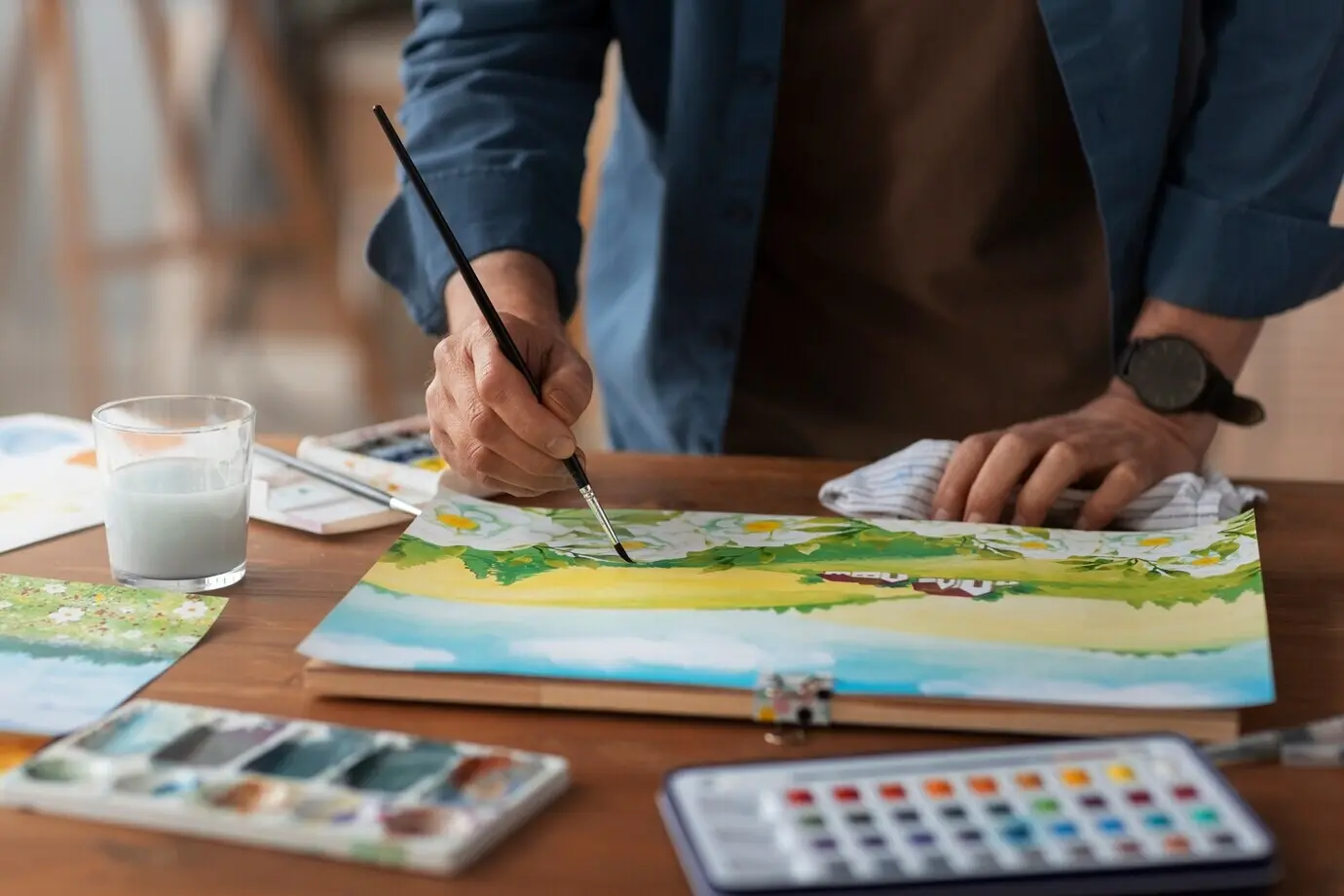 Älterer Maler, der für seine Kunst Aquarell verwendet.